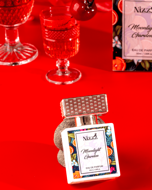 Moonlight Garden Eau de Parfum 50ml by Nizzz Perfumes – unisex fragrance bottle with floral and citrus design, displayed on a vibrant red background
