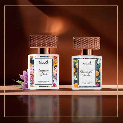 Two Nizzz floral perfume bottles, Tropical Oasis and Moonlight Garden, with woven caps and vibrant labels on reflective surface