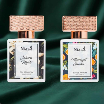 Two Nizzz floral perfumes: Sahara Nights & Moonlight Garden, 50ml eau de parfum bottles with rose gold caps on green velvet
