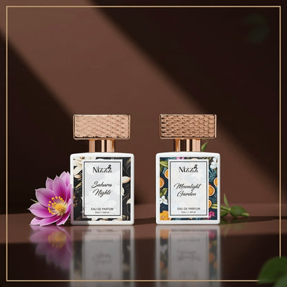 Two elegant Nizzz floral perfume bottles, Sahara Nights and Moonlight Garden, with pink flower accent on reflective surface