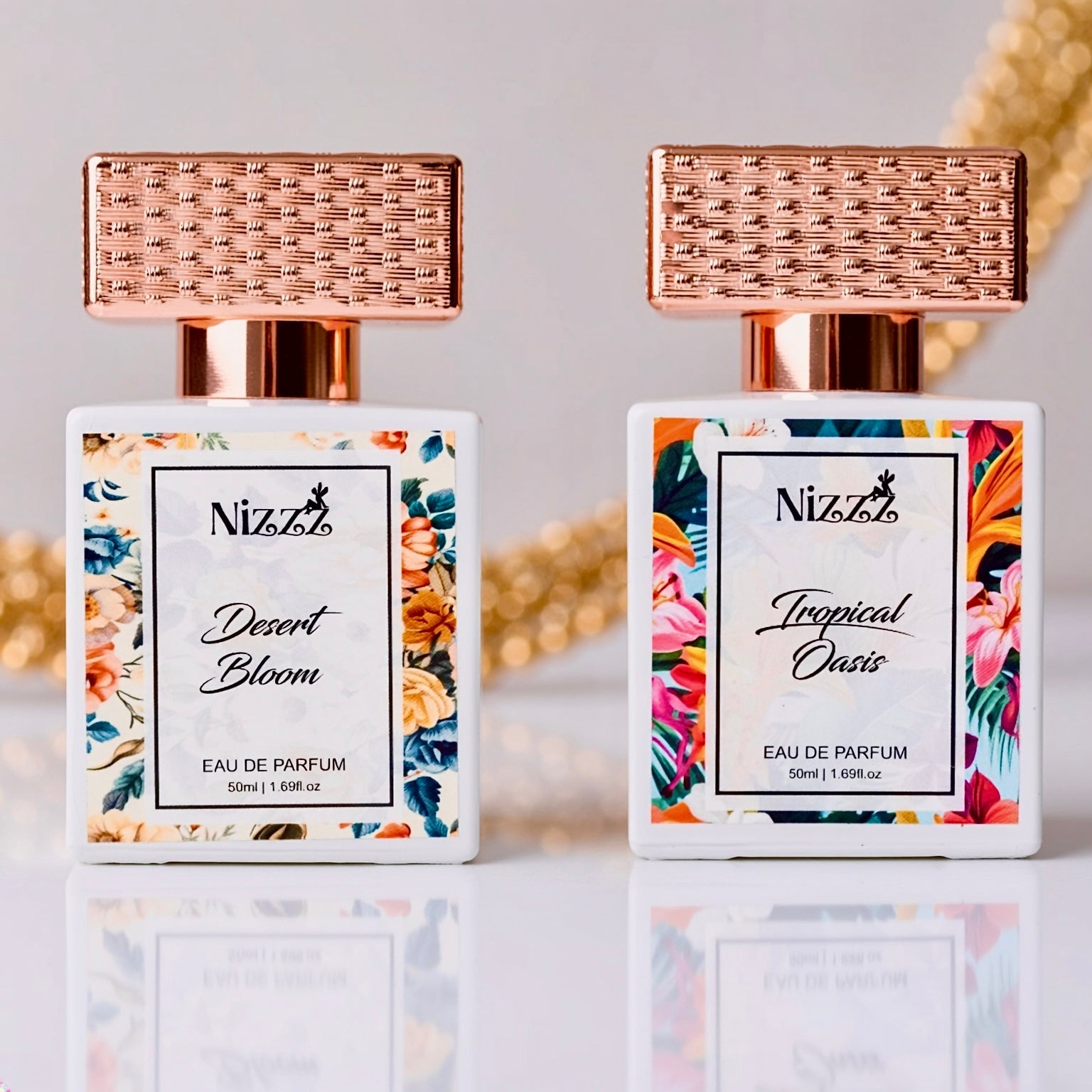 Two floral perfume bottles: Desert Bloom & Tropical Oasis Eau de Parfum with rose gold caps, 50ml each