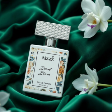 Nizzz Desert Bloom luxury perfume bottle on emerald green fabric with white flowers
