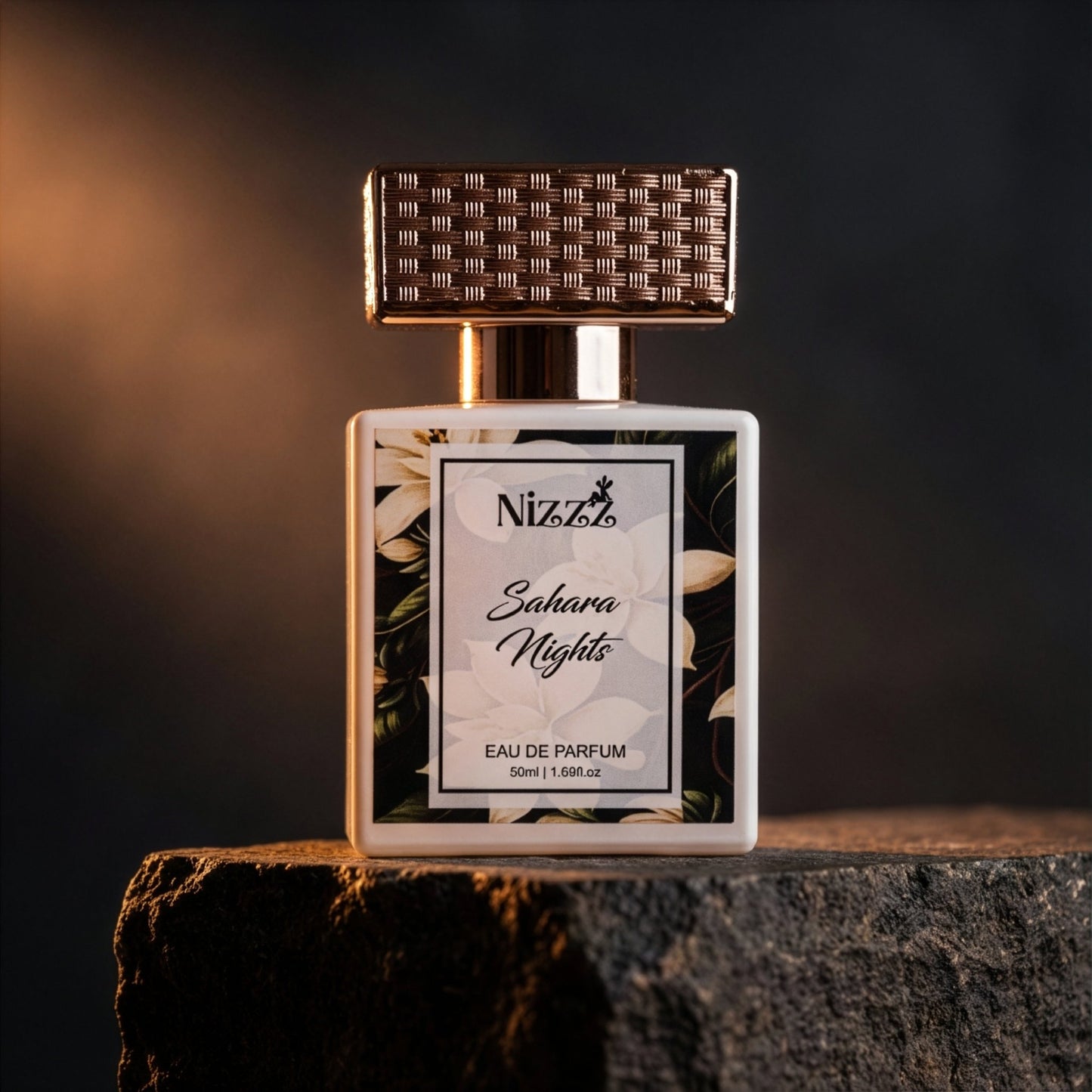 Nizzz Sahara Nights Eau de Parfum bottle with floral label and textured cap on stone surface